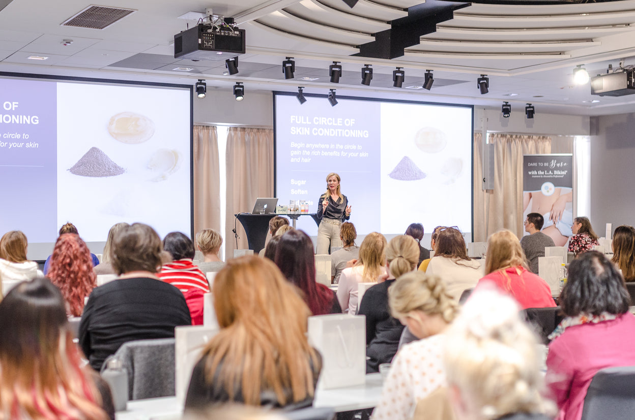 image of founder and ceo Lina Kennedy speaking at an Alexandria Professional beauty conference in Finland.